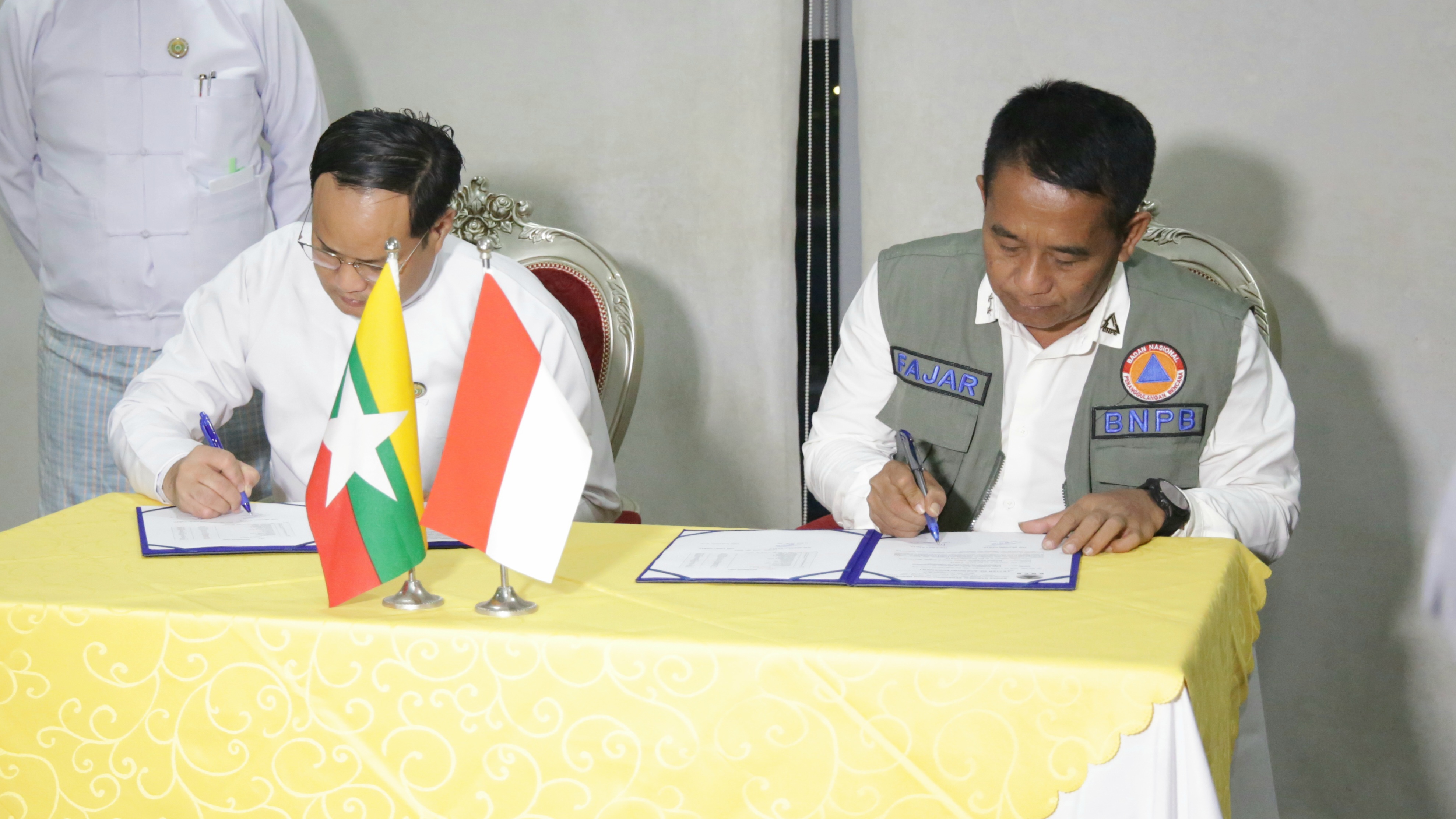 Deputi Penanganan Darurat BNPB Mayjen TNI Fajar Setyawan (kanan) menandatangani berita acara penyerahan bantuan kemanusiaan Masyarakat Indonesia untuk Masyarakat Myanmar pasca siklon Mocha di Yangon, Myanmar, Senin (26/6).